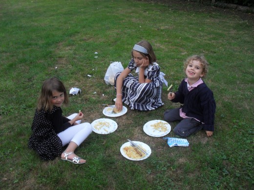 Children entertaining themselves, having a snack while the parents were enjoying a cocktail.  Notice how even though having a sort of picnic they still have proper cutlery!