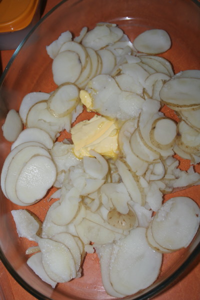 Some butter was added to the baking dish, the potatoes went for a slicing and lined the baking dish