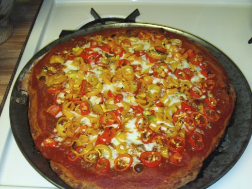 Pizza with diced red and yellow bell peppers.