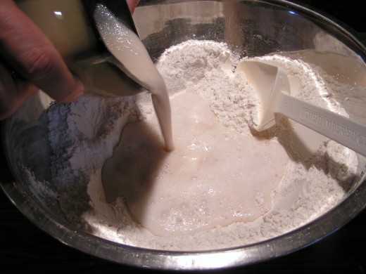 Pouring yeast mixture into depression in flour mixture.