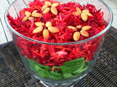 Shredded Carrot, Beet, & Apple Slaw served on a bed of baby spinach & topped with almond flowers.