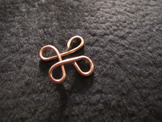 Make the fourth loop, completing the clover link.