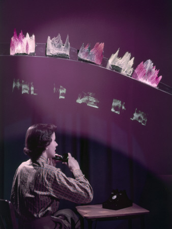 A Woman Speaks in a Phone in a Room with Models of Voice Patterns, by Willard Culver