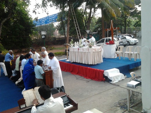 Amidst the trees, a view of the specially erected altar and communion table, with the organist in the side.