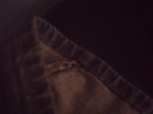 This is your typical faded bluejeans pants hem with bulky side seam at hem and dark gold thread stitching