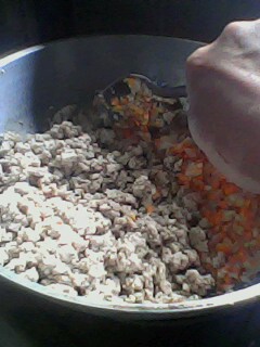 Mixing the ground pork to the spices and veggies