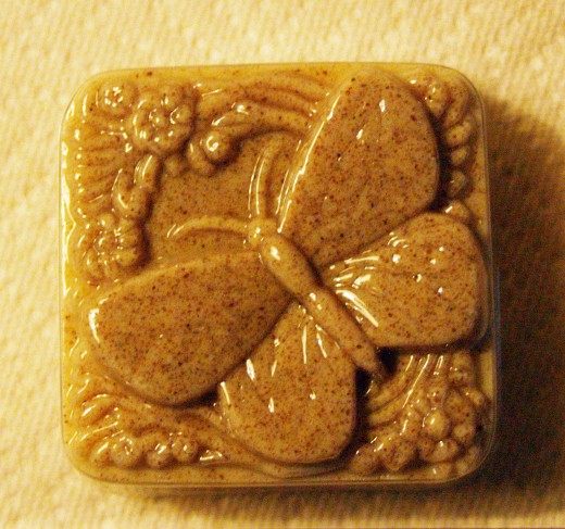 A soap mold with daisies and a butterfly (a mariposa) was used for this soap. Yellow colorant, lemon essential oil, and almond meal were added to white melt and pour glycerin soap base.