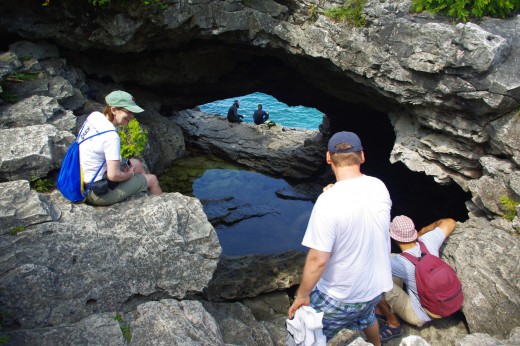 Visitors looking down a hole to see two snorkelers.