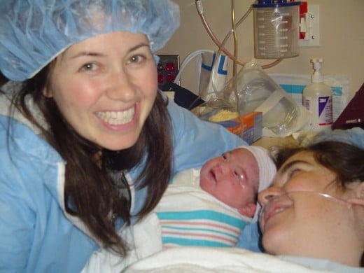 A newborn baby with mother and doula.