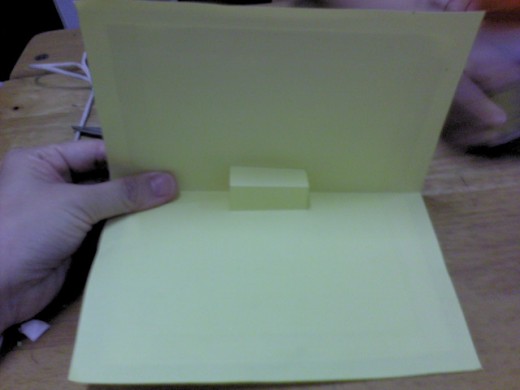 Lower down the top card and it will automatically stick to the top part of yellow construction paper