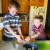 Both boys crush meringue cookies and add them to the cream. Both boys crush meringue cookies and add them to the cream.