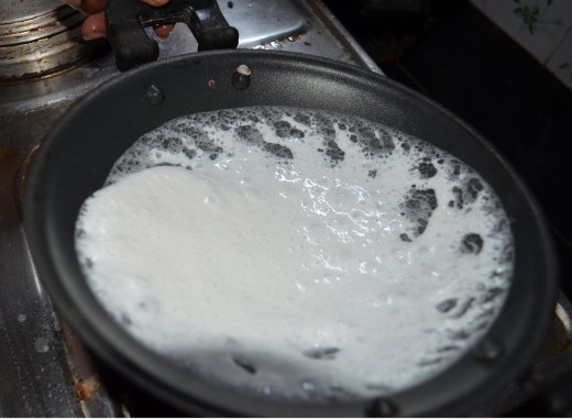 Twisting the pan to make the Appam