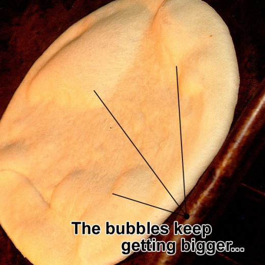 More bubbles form on the pita as it bakes.