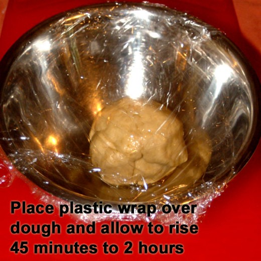 Cover the oiled dough ball bowl with plastic wrap.
