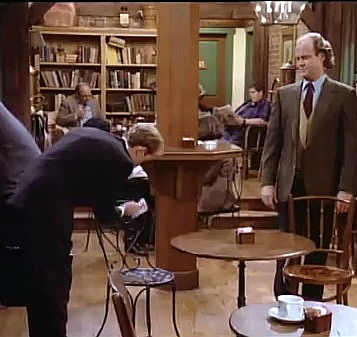 Frasier observes as his fastidious brother cleans a cafe chair.