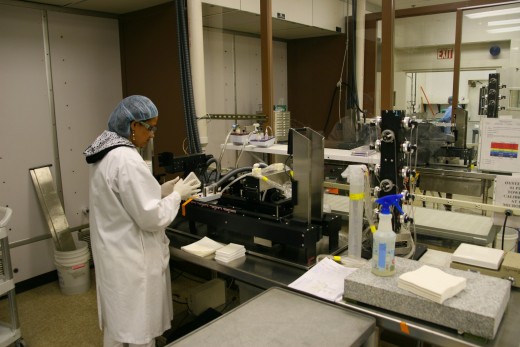 A manufacturing technician prepares a machine to coat microtiter plates.
