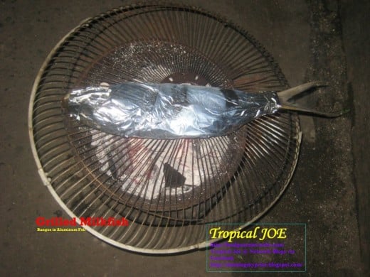 Grilled Milkfish - or bangus, warpped in aluminum foil, filling consists of spices (onion, garlic, pepper, tomatoes, salt, lemon or vinegar and  ground black pepper)
