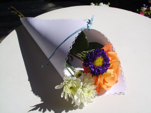 Decorated Paper Wrap for floral arrangement wedding favor for guests. Flowers are from Village Gardens in Blue Springs, Missouri.