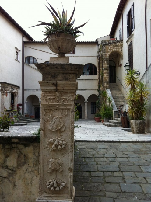 Inside the medieval feeling courtyard leading to a communal piazza that feels Renaissance.