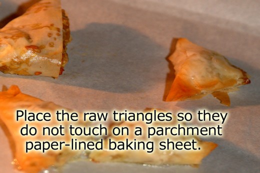 Place the raw stuffed triangles on a baking sheet that is lined with parchment paper. Make sure they do not touch. 