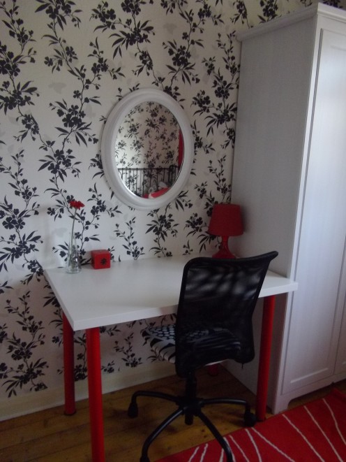 Desk with red legs. Black and white wallpaper.