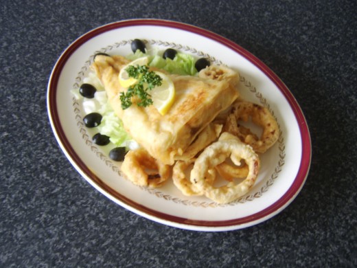 A boned fillet of coley is dipped in a flour batter and served with battered onion rings and salad