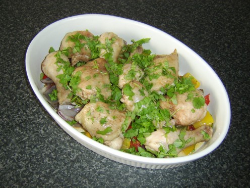 Chicken legs and thighs are roasted and served on a variety of Mediterranean vegetables