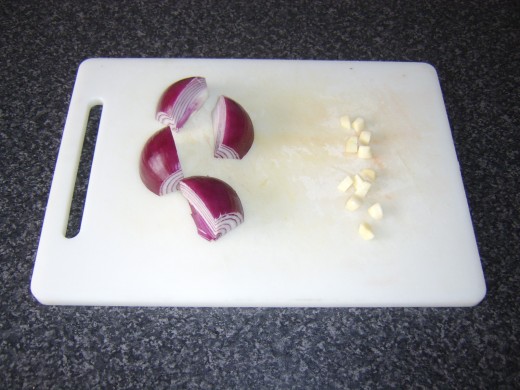 Red onion is peeled and quartered, garlic cloves are peeled and roughly chopped