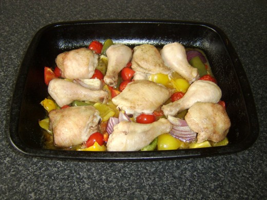 Chicken portions and vegetables are removed from the oven