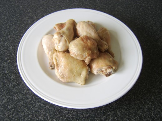 Chicken pieces are temporarily removed to a holding plate