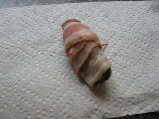 Wrap stuffed peppers with bacon and secure with a toothpick.