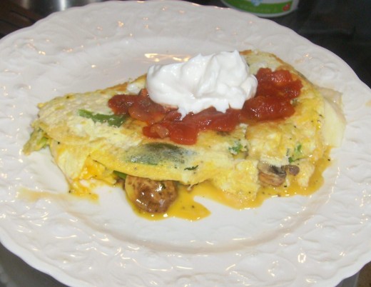 Filled omelet topped with salsa and sour cream.