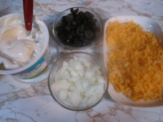Sides of chopped olives and onions, shredded cheese, and sour cream