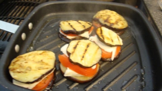 Once they are assembled, flipping is unneccessary.  Simply cover for a couple of minutes to allow the cheese to melt.