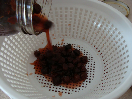 Straining the cherries will separate the cherry juice from the actual fruit.  This will allow a smooth liqueur to be made.