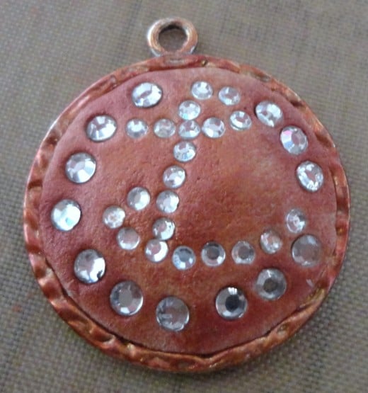 Here, I used the cheapest (but high-quality) glass rhinestones to create this pendant, then dusted with some pearl powder. Note that this is intentionally made uneven to complement this bezel I antiqued with alcohol inks, sealer, and acrylic spray. 