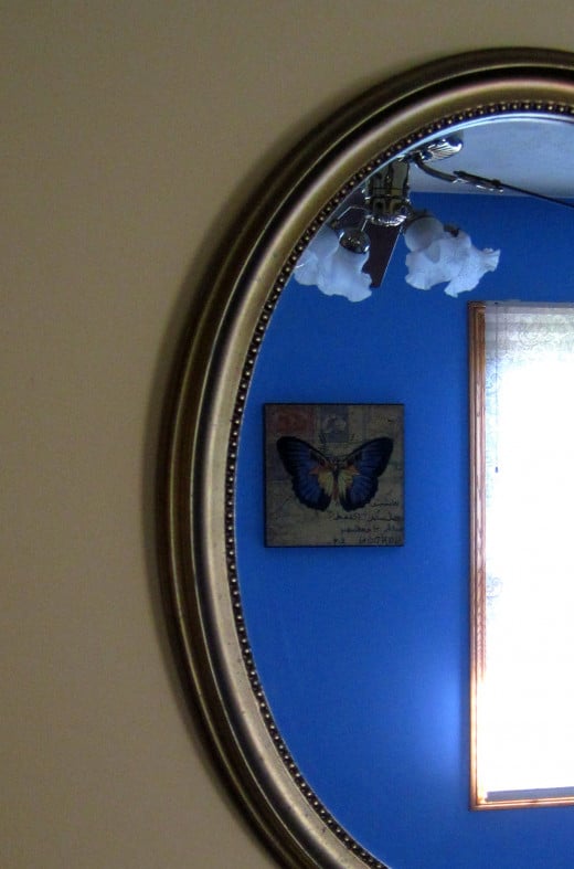 Gold oval mirror reflects the rich blue interior.