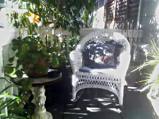 This is the porch of my last home that was decorated in shabby chic style. The chair was worn wicker with a mismatched pillow and an old vintage angel table. It was so cozy!