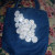 Denim tote with white sequin fabric embellishments. These are multiple layered flowers.