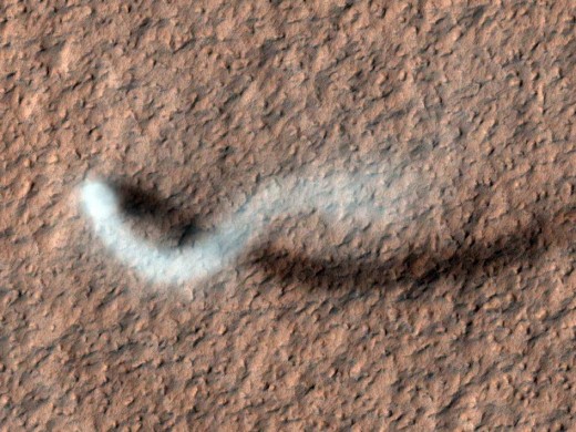 Dust devils on Mars can be tall: this one is half a mile, but another 12-mile-tall one was detected in March 2012. They slither across the surface frequently, sometimes leaving odd trails on the surface.
