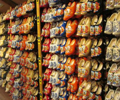 To buy wooden shoes at Zaanse Schans is somewhat less expensive than in Amsterdam.  You will have a wide variety to choose from.