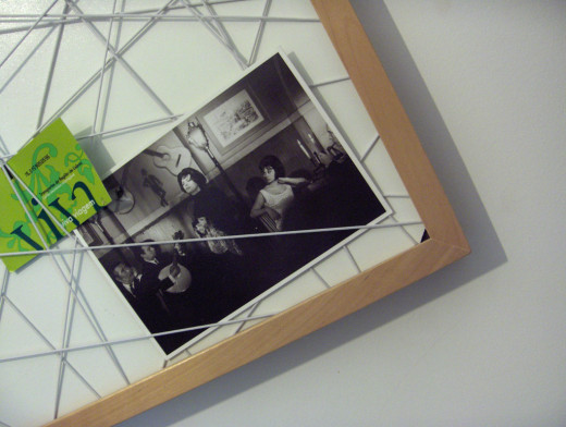 One idea is to wrap ribbon or string around the board and slip notes or photos in between