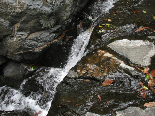 Water running down the crevice between two rocks.