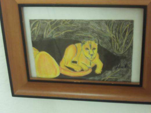 The framed lion drawing is now hanging on the wall.