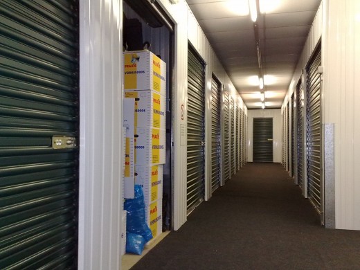 Corridor with self-storage units. Indoor self storage units are best, but they are more costly. I use outdoor self storage units that are very close to where I live. They are cheap and very efficient.