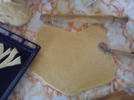 The rolling pin behind the dough was used to make a thin, consistent dough base.  The cookie sheet on the left shows how the pieces are slightly opened when baked.