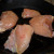 Fresh, skinless, bone in chicken breast in the skillet beginning the browning process.