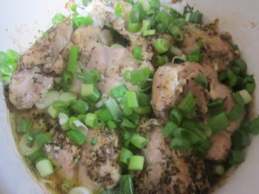 Add green onions to chicken thighs.