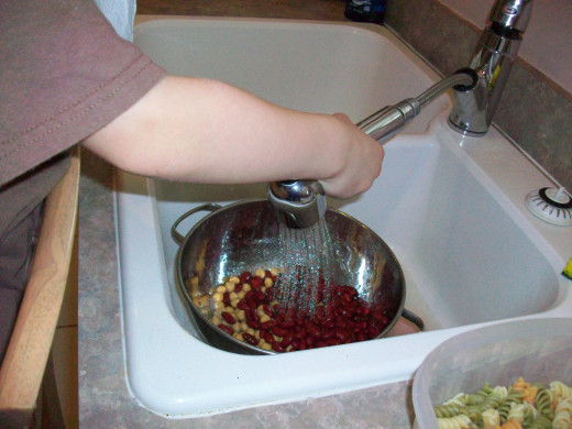 Rinsing canned beans is a simple task for preschoolers -- just pull up a chair to the sink for them to kneel on!