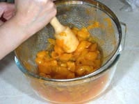 Grate pitted and boiled cherry plum in a colander.